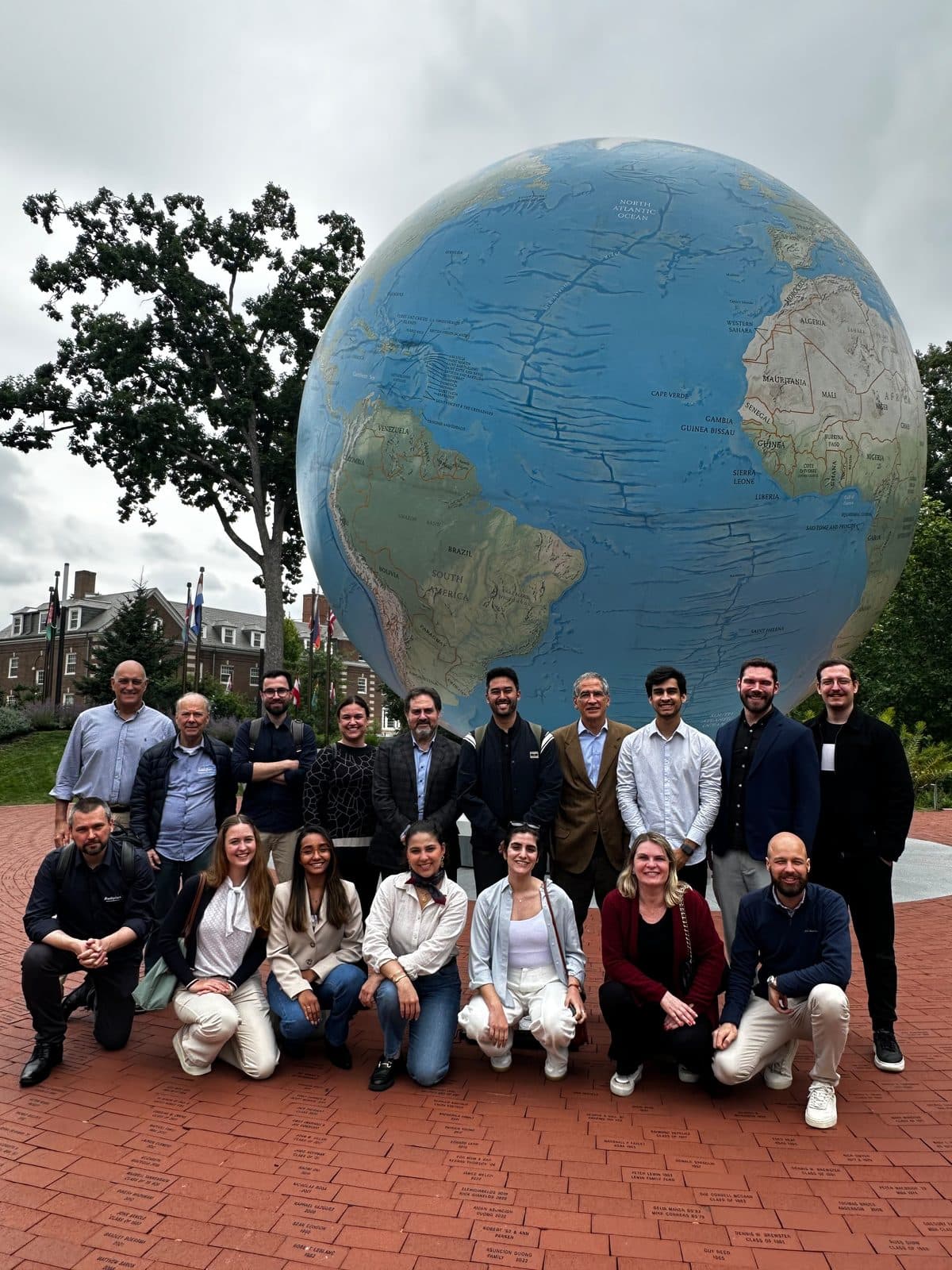 Grupo de participantes diante do globo do Babson College