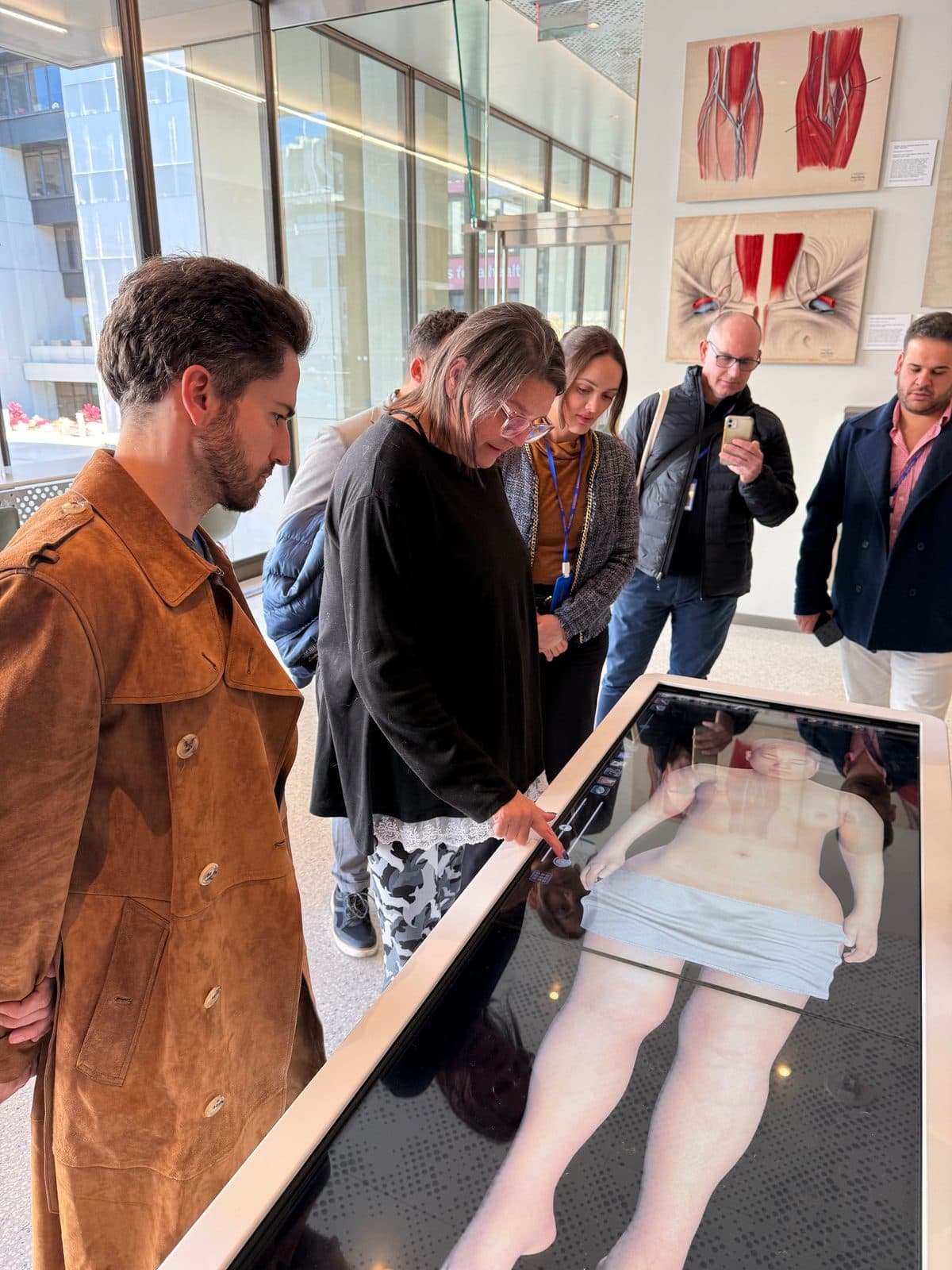 Participantes exploram uma mesa digital de anatomia
